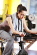 A young woman riding an exercise bike