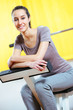 Beautiful sporty girl is smiling and resting in a gym.
