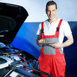 Motor mechanic in a garage working with touchpad