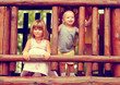 Photo in sepia of brother and sister playing on the playground