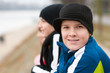 Cute smiling teenage boy outside with friends in the background