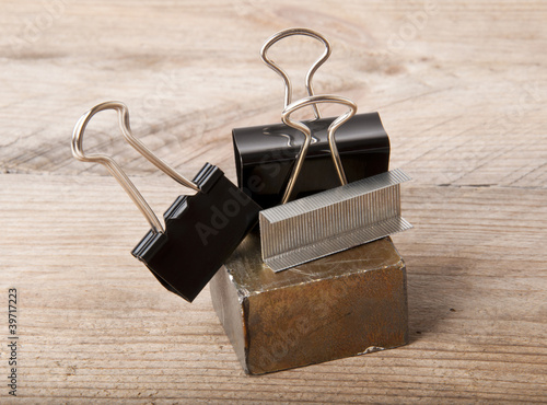 Photo: paper clips and a magnet on a wooden background paper clips and a magnet on a wooden background