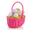 cheerful easter eggs in a pink wicker basket isolated over white