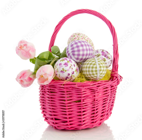 Photo: cheerful easter eggs and tulips in a pink wicker basket isolated cheerful easter eggs and tulips in a pink wicker basket isolated