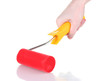 bright paint roller in hand isolated on white bright paint roller in hand isolated on white
