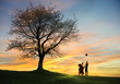 Children playing in sunset with ball, silhouettes