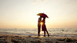 Couple kissing under umbrella at the beach in sunset. Couple kissing under umbrella at the beach in sunset.