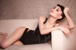 Beautiful sexy fashion girl in black corset lying on the sofa