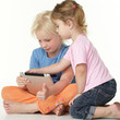 Two cute children sitting on the floor and playing with touchpad Two cute children sitting on the floor and playing with touchpad