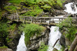 Wooden bridge over Saent waterfalls in the Italian mountains Wooden bridge over Saent waterfalls in the Italian mountains