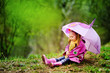 smiling little girl with umbrella in the park