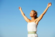 Beautiful young woman with arms raised