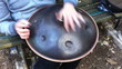 A guy playing hang drum on a bench A guy playing hang drum on a bench