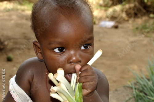 Photo: Zahnendes afrikanisches Baby kaut auf Gemüse Zahnendes afrikanisches Baby kaut auf Gemüse