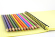 Color pencils on the yellow writing-book Color pencils on the yellow writing-book
