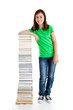 Student standing close to pile of books on white