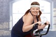 Photo: Happy woman on exercise bike Happy woman on exercise bike