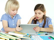 Photo: Two cute girlfriends learning with books and touchpad Two cute girlfriends learning with books and touchpad