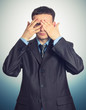 Young businessman looking through his fingers
