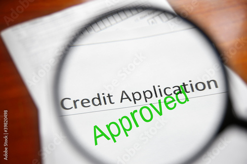 Photo: magnifying glass and approved credit application form magnifying glass and approved credit application form