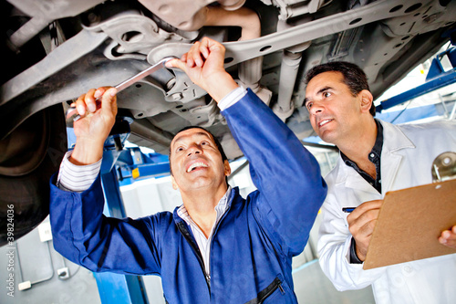 Photo: Mechanics working under a car Mechanics working under a car