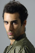 Photo: Close up portrait of shy young man on gray Close up portrait of shy young man on gray