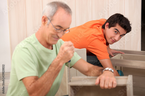 Photo: Grandfather helping grandson with the furniture Grandfather helping grandson with the furniture