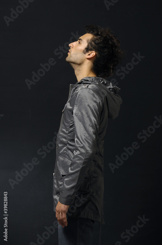 Photo: young man in a casual style clothing on black background young man in a casual style clothing on black background