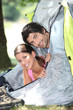 Young couple sticking their heads out of a tent door