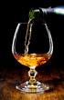Cognac glass and bottle on a black