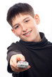Happy teenage boy changing channels with remote control
