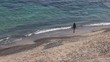 CHICA RECOGIENDO PIEDRAS EN LA ORILLA DEL MAR