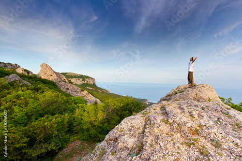Photo: hiker at the top of a rock with his hands up enjoy sunny day hiker at the top of a rock with his hands up enjoy sunny day