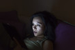 Young woman reading a tablet in the dark