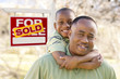 Photo: Father and Son In Front of Sold Real Estate Sign Father and Son In Front of Sold Real Estate Sign