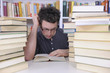 Foto: Student researching with books in a library Student researching with books in a library