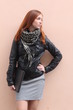 Redhead young woman standing outside with her laptop
