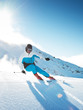 Skier in mountains, prepared piste and sunny day