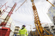 construction site and geodetist, cranes and scaffoldings