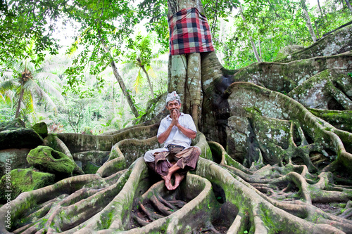 Photo: Spiritual man sits under the tree, Bali Spiritual man sits under the tree, Bali
