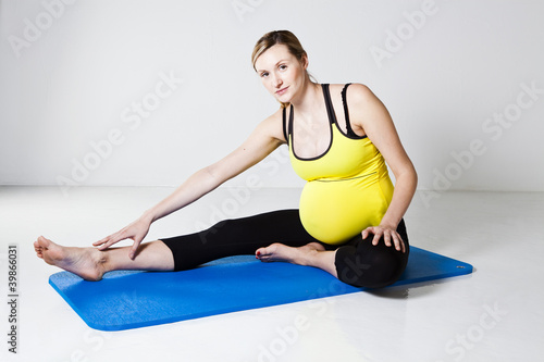 Photo: Pregnant woman performing leg stretch Pregnant woman performing leg stretch
