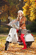 Photo: Portrait of beautiful young woman on scooter Portrait of beautiful young woman on scooter