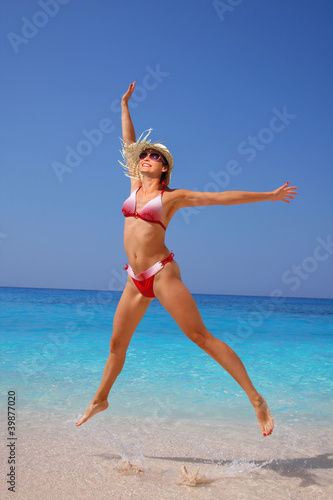Photo: Happy sexy woman jumping on the beach Happy sexy woman jumping on the beach