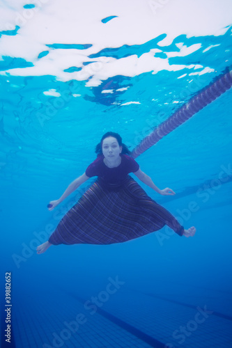 Photo: Woman swimming in the pool in clothes Woman swimming in the pool in clothes