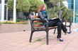 Pretty woman working on her laptop, sitting on a bench