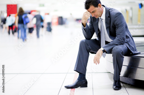 Photo: worried businessman lost his luggage at airport worried businessman lost his luggage at airport