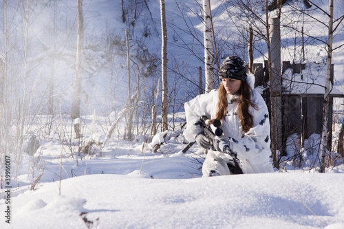 Photo: Sniper girl in white camouflage at winter forest. Sniper girl in white camouflage at winter forest.