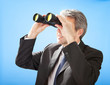 Senior businessman looking through binoculars