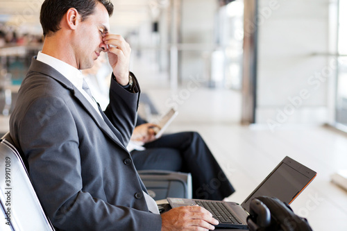 Photo: tired businessman taking a break at airport tired businessman taking a break at airport