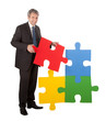 Senior businessman assembling a jigsaw puzzle